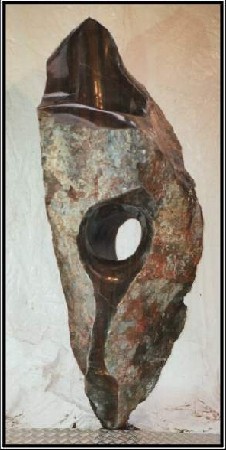 The work VII/2 is a big sculpture from serpentine over 2m high. It has one vertical and two horizontal holes. The holes are polish inside. Outside the stone is naturally leave.